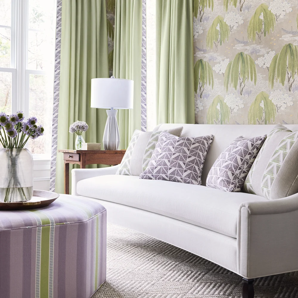 Anna French Willow Tree roomset in a bright living room with willow-tree wallcovering, pale green curtains, patterned cushions, and a white sofa.