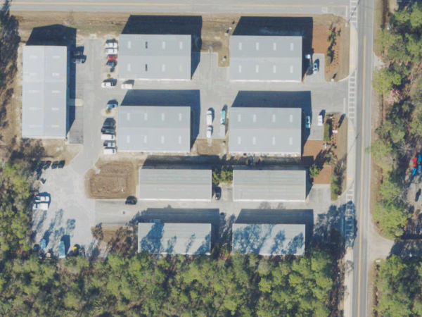 North-up aerial view of the showroom complex beside South County Highway 393, with The Fabric Source showroom marked in Building 8