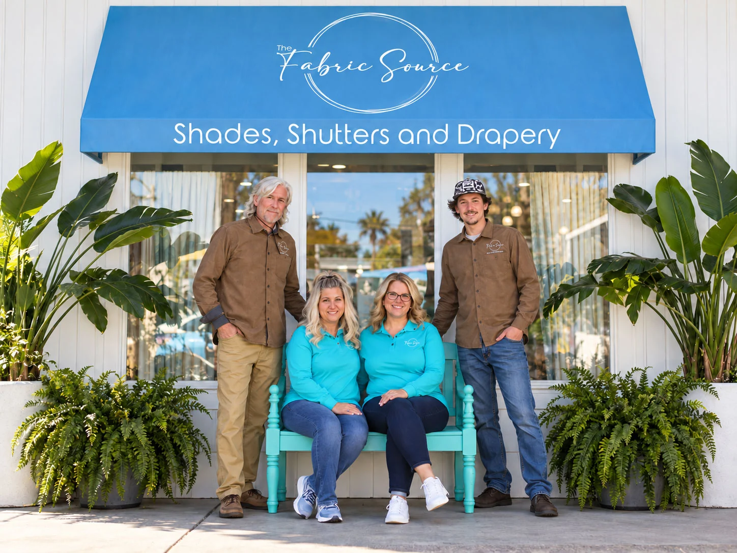 Four Fabric Source team members beneath the branded showroom awning