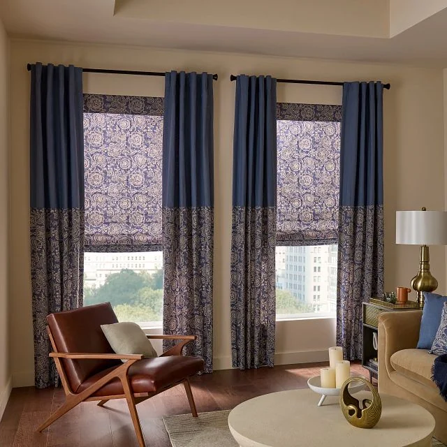 Natural woven Horizons shades layered with drapery in a living-room setting