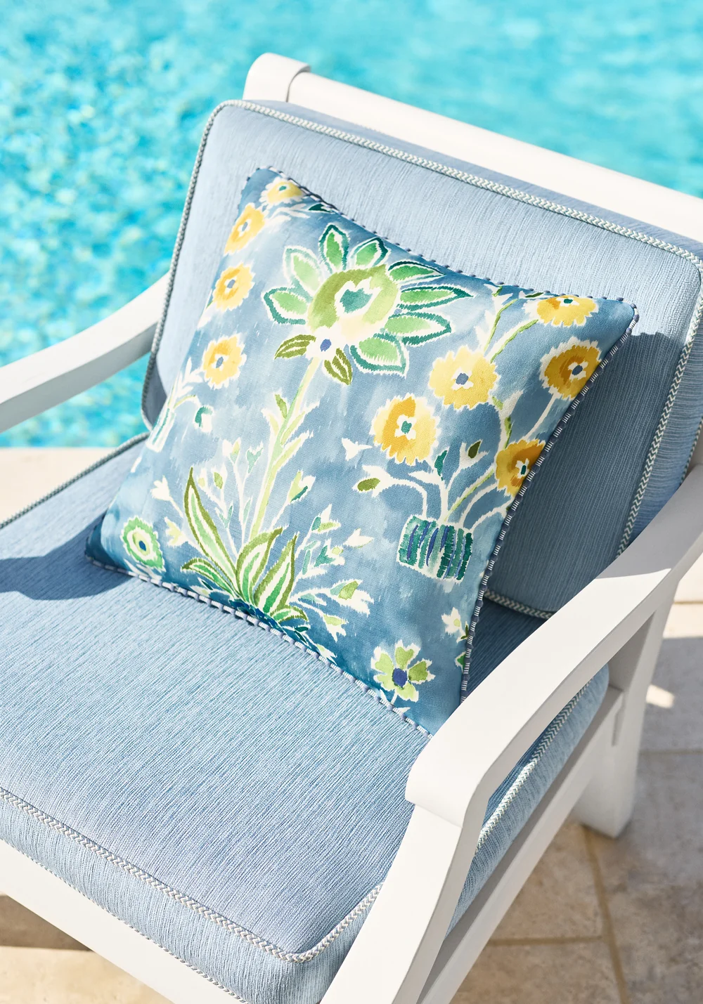 Blue upholstered chair with a botanical accent cushion in a Thibaut Acadia interior